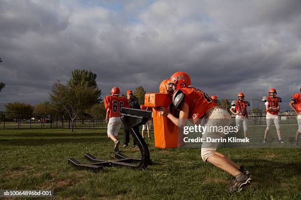 american football players including teenagers (15-17) training in field - praticando imagens e fotografias de stock