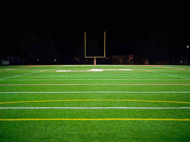 american football field at night - football stock pictures, royalty-free photos & images