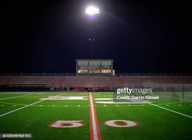 illuminated american football field at night - urban football pitch stock pictures, royalty-free photos & images