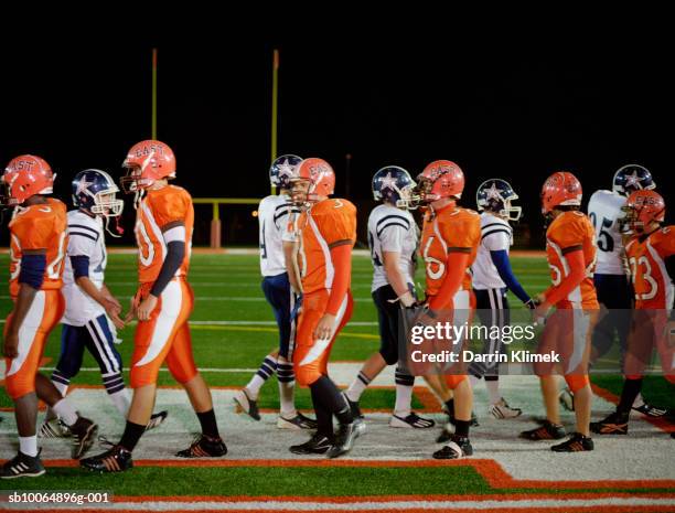 meeting of teams of american football in field, side view - orange uniform stock pictures, royalty-free photos & images
