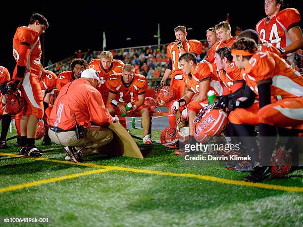 american football players including teenagers (15-17) and coach planning tactics - american football sport stock pictures, royalty-free photos & images