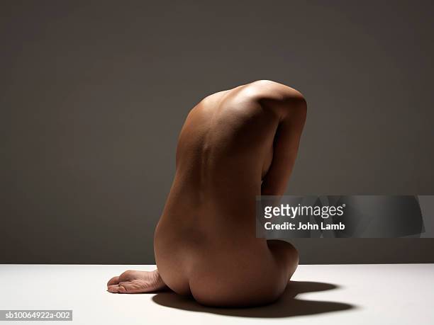 naked woman sitting, rear view - femminilità foto e immagini stock