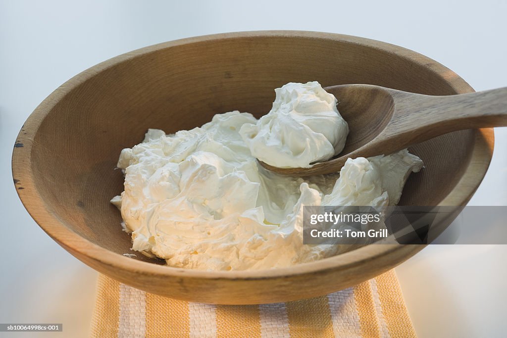 Wooden bowl of whipped cream, close-up