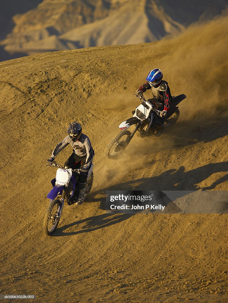 Two men motocross riding in desert terrain