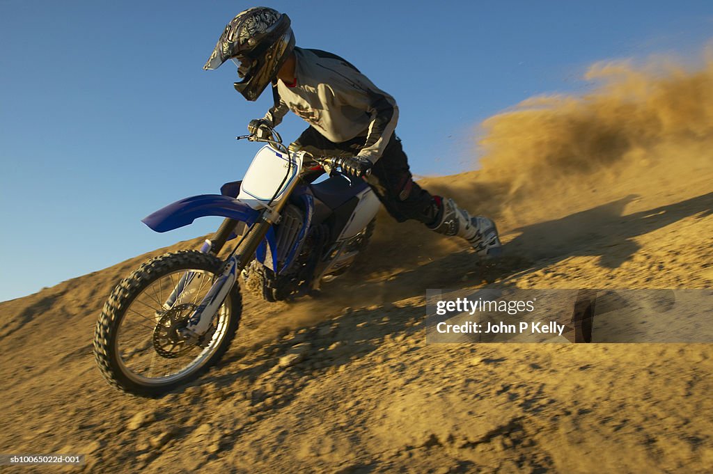 Man motocross riding in desert terrain