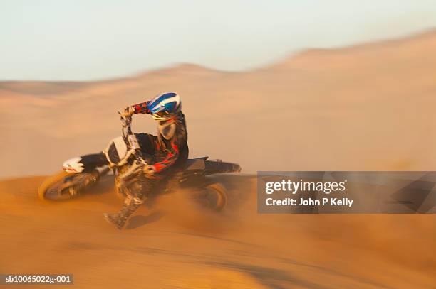 man motocross riding in desert terrain - motorrace stockfoto's en -beelden