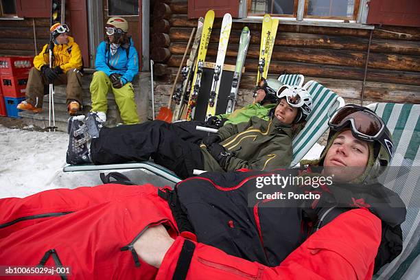 switzerland, davos, group of skiers resting outside cabin - après ski stockfoto's en -beelden