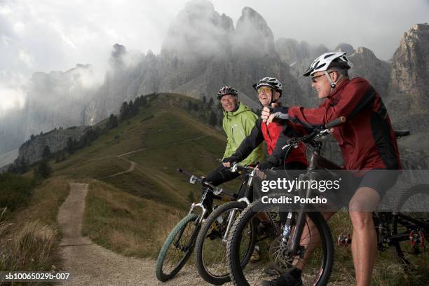 italy, tyrol, senior bikers resting on mountain bikes on ridge, side view - young at heart fotografías e imágenes de stock