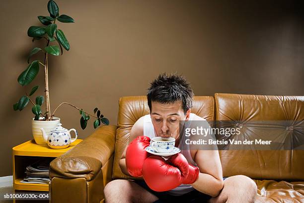 boxer drinking tea on sofa - leather vest stock pictures, royalty-free photos & images