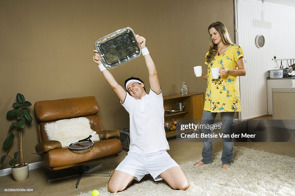 Woman holding tea cups, man with tray