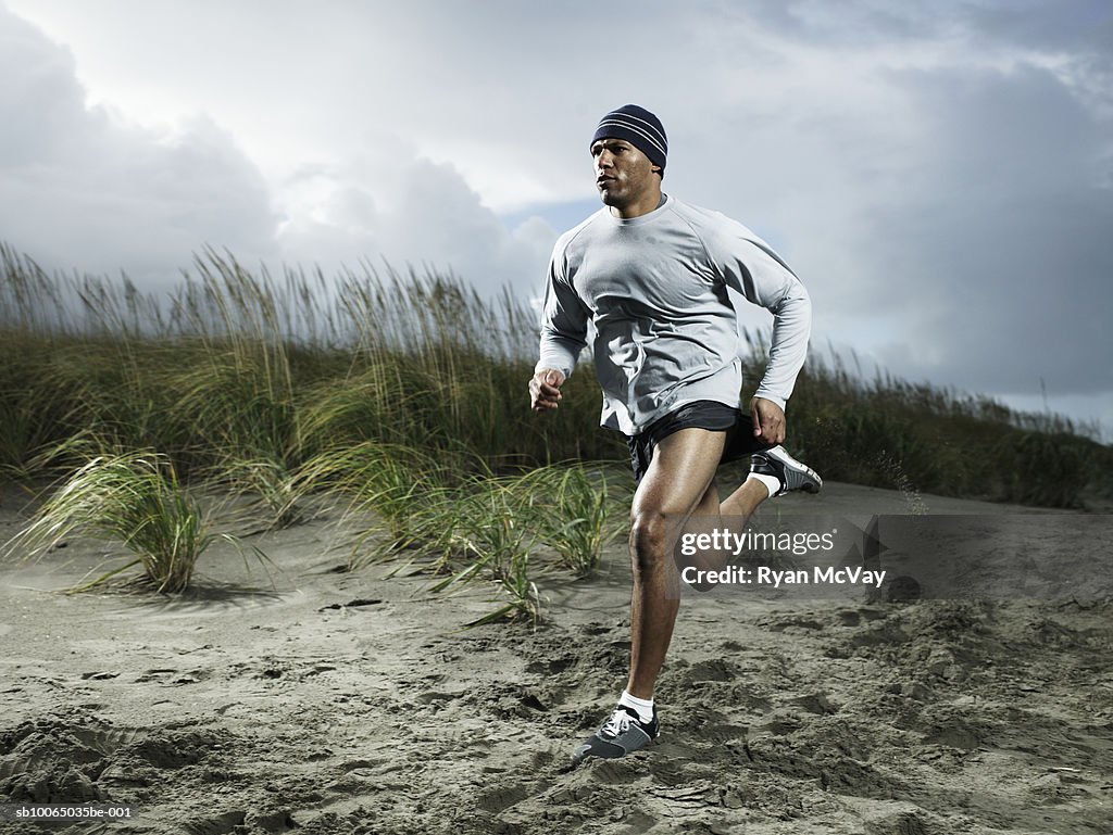 Muscular man running on beach