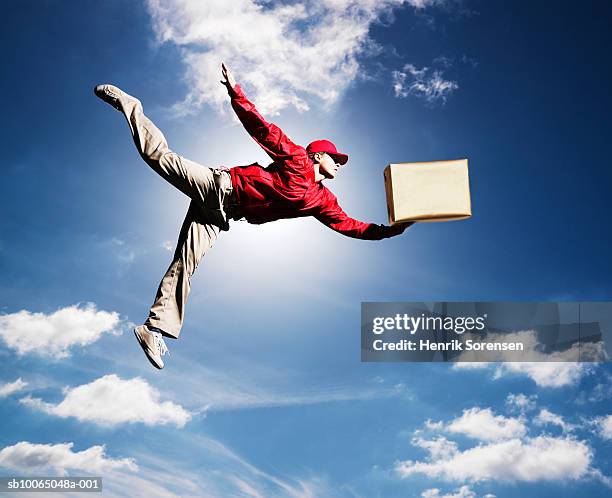 man flying in sky with box in one hand, low angle view - 配達員 ストックフォトと画像