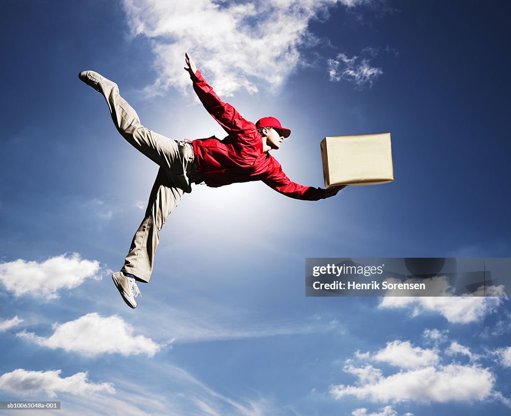 Small Flying Man Man Flying In Sky With Box In One Hand Low Angle View High-Res Stock ...