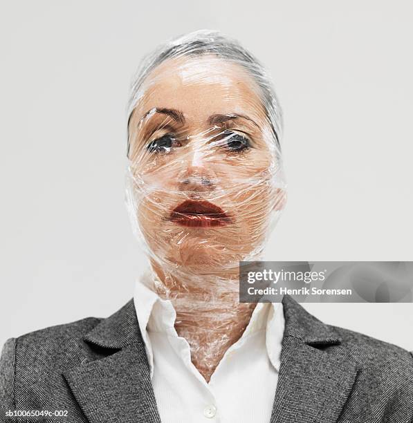 businesswoman wrapped in plastic wrap, close-up, portrait - cellophane photos et images de collection