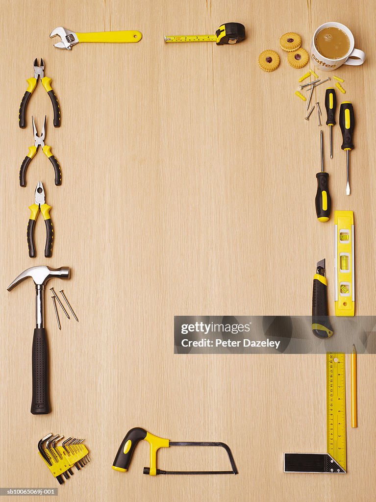 Tools with yellow handles and cup of coffee on table