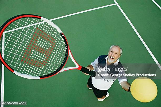 senior man playing tennis, elevated view - racket sport stock-fotos und bilder