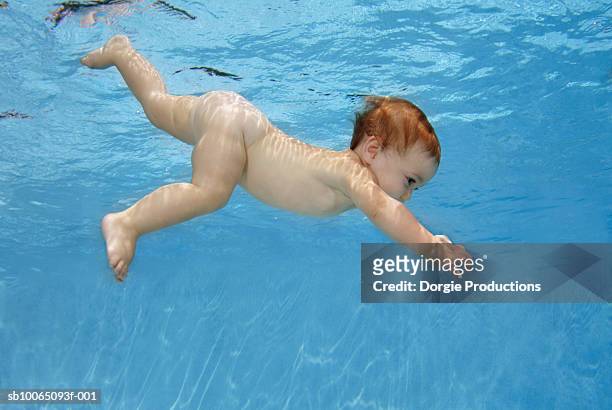 baby girl (11 months) underwater in pool - babyschwimmen stock-fotos und bilder