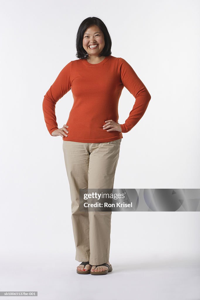 Mature woman standing against white background, portrait