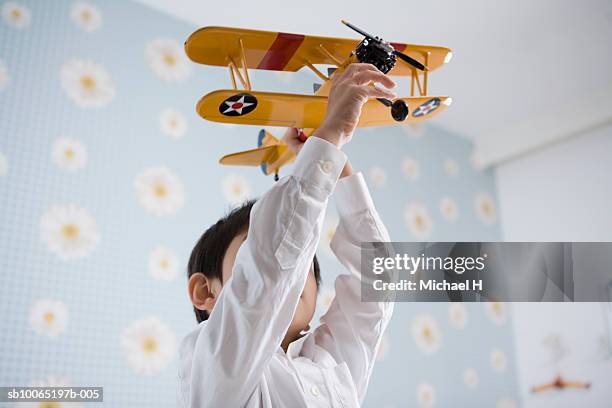 boy (4-5 years) playing with toy airplane indoors, low angle view - 4 5 years foto e immagini stock