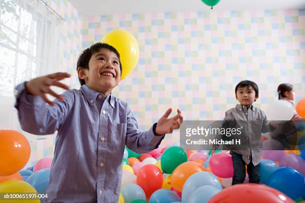 children (4-5 years) playing in room filled up with balloons - gruppe h spiel stock-fotos und bilder
