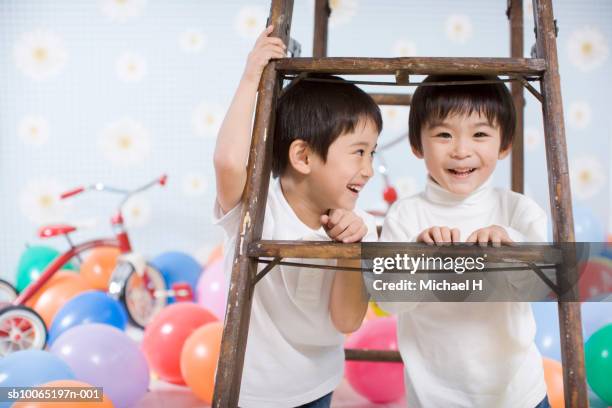 two boys (4-5 years) smiling under stepladder - 4 5 years balloon stock pictures, royalty-free photos & images