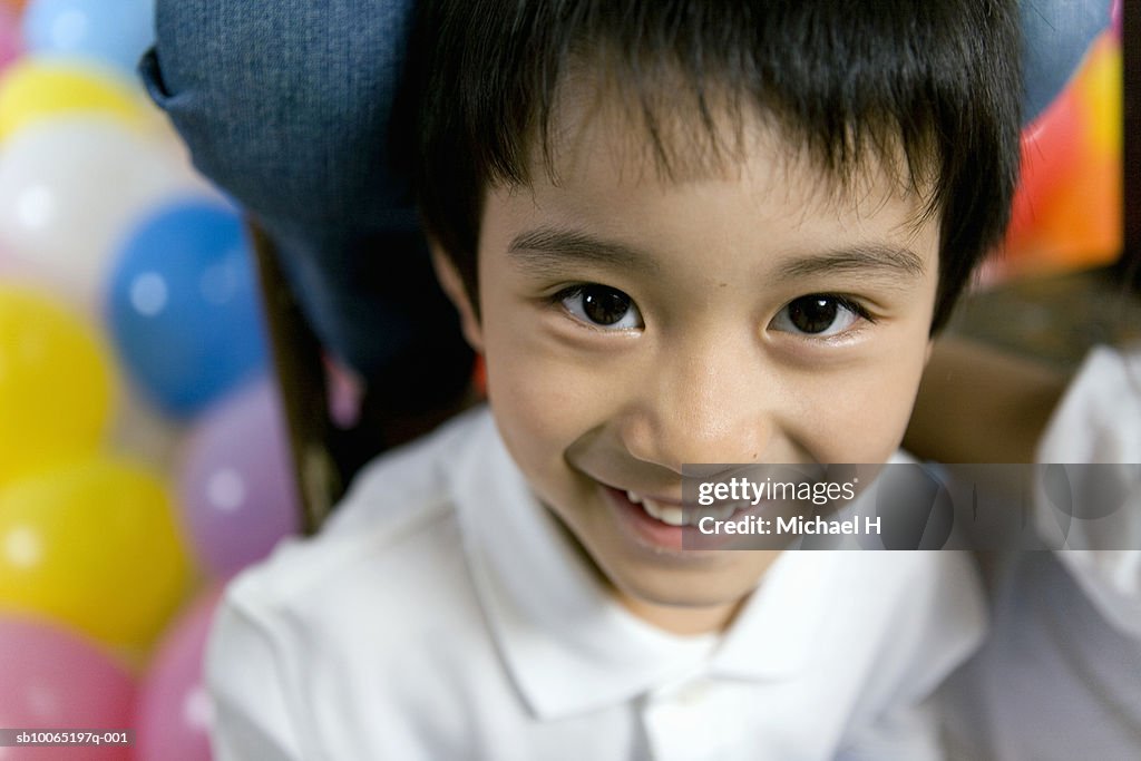 Boy (4-5 years) sitting on stepladder, portrait, elevated view, close up