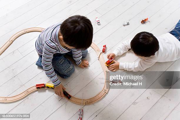 two boys (4-5 years) playing with toy train set, elevated view - 4 5 years stock pictures, royalty-free photos & images