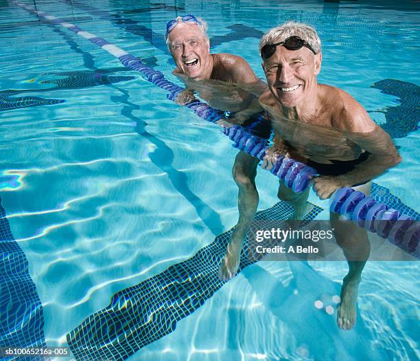 portrait of two senior men in pool - joven de espíritu fotografías e imágenes de stock