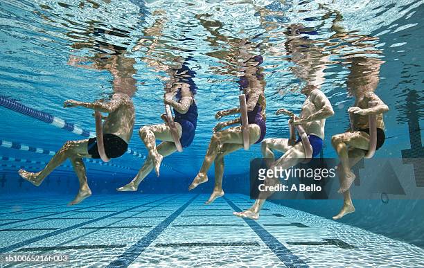 five senior people in swimming pool, underwater, low section - aquatic sport stockfoto's en -beelden