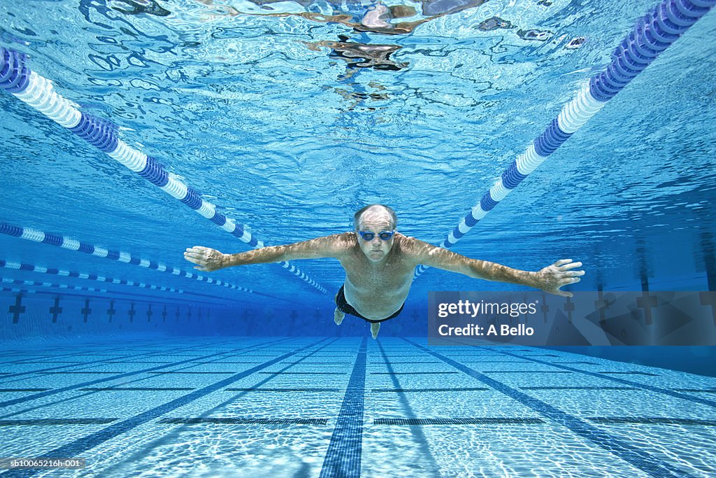 Senior man swimming in pool, underwater view
