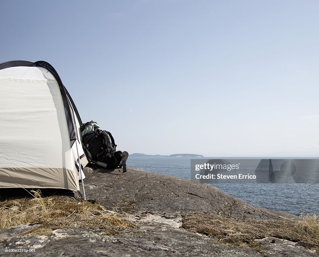 Backpack and tent on seashore