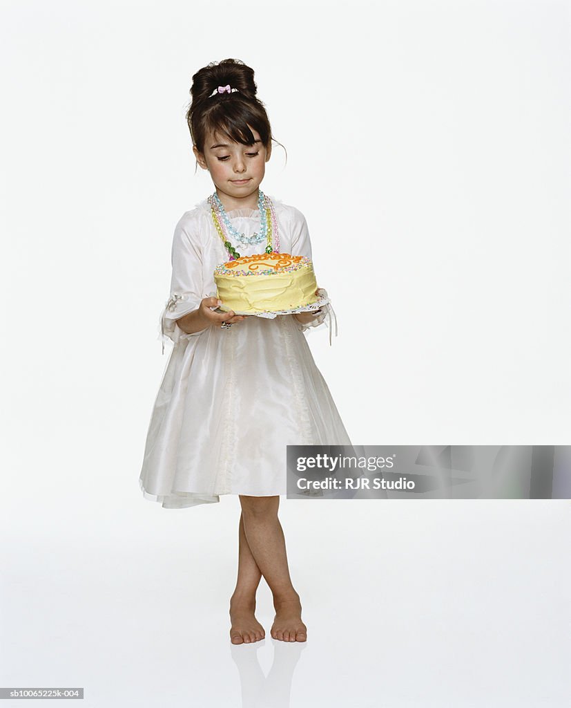 Girl (6-7) holding birthday cake, close-up