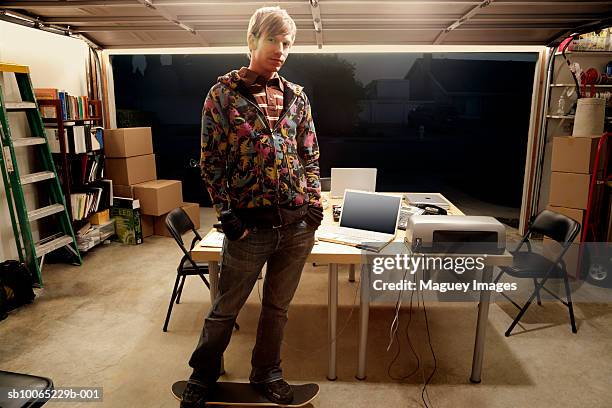 man standing in garage with table of laptops, portrait - garage doors stock pictures, royalty-free photos & images