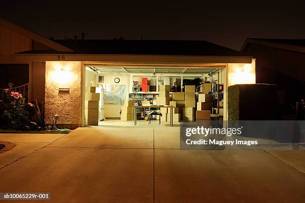 illuminated garage with open door - autobergplaats stockfoto's en -beelden