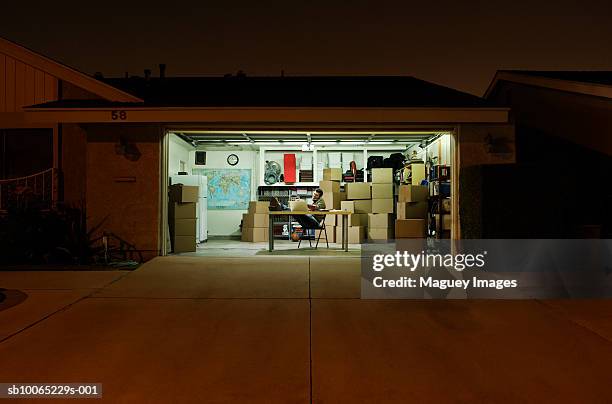 man working in garage at night - autobergplaats stockfoto's en -beelden