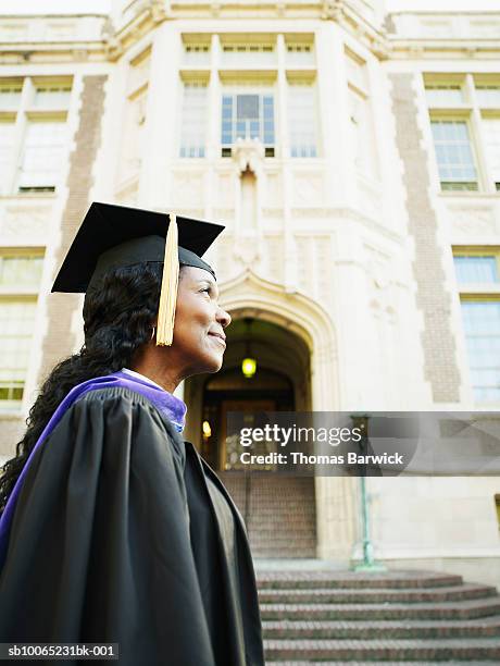 mature woman in front of college in graduation gown, profile - black woman graduation stock pictures, royalty-free photos & images