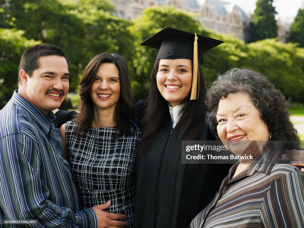 Female college graduate in gown with parents and grandmother, portrait