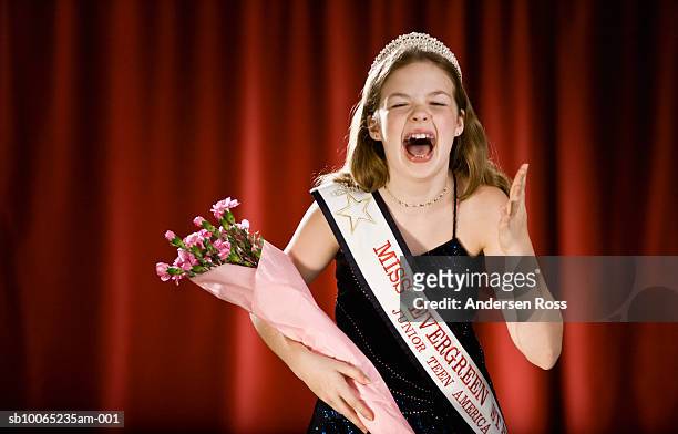 girl (11-13) screaming on stage with bouquet of flowers in beauty pageant - beauty pageant crown stock-fotos und bilder