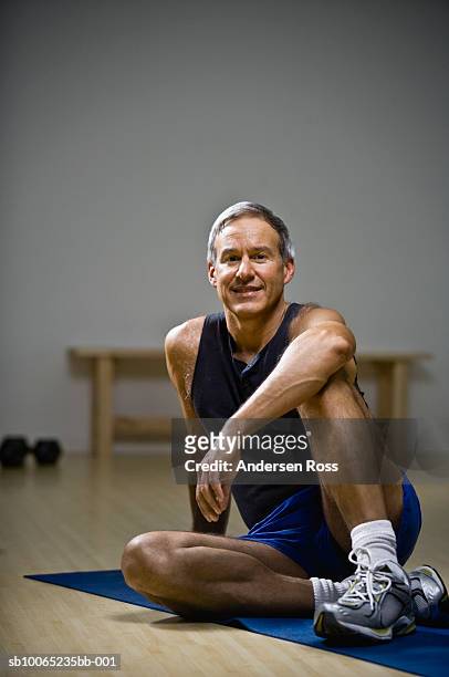 mature man sitting on floor in gym, portrait - yoga mat stock pictures, royalty-free photos & images