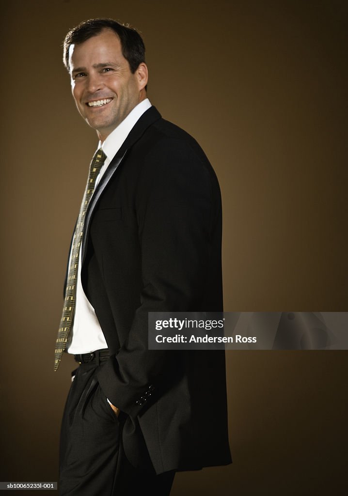 Businessman smiling, portrait, studio shot