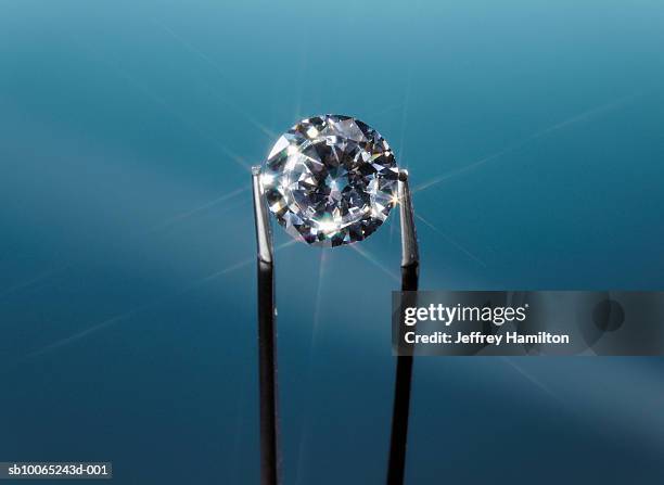 tweezers holding diamond, close-up - diamant stockfoto's en -beelden