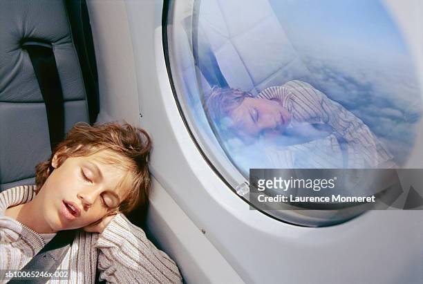 boy (8-9) sleeping in aeroplane - airplane window exterior stock-fotos und bilder