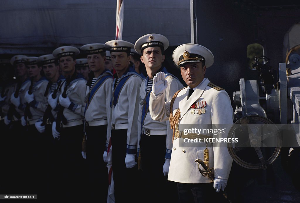 Navy officers standing in row on deck of naval ship