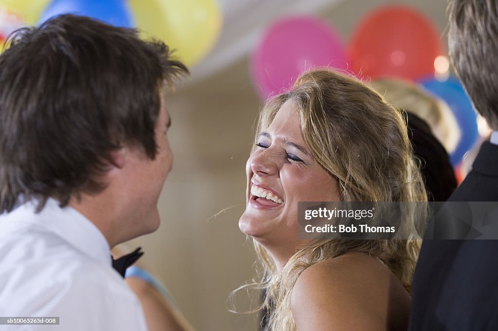 Young couple dancing in party, laughing (focus on foreground)