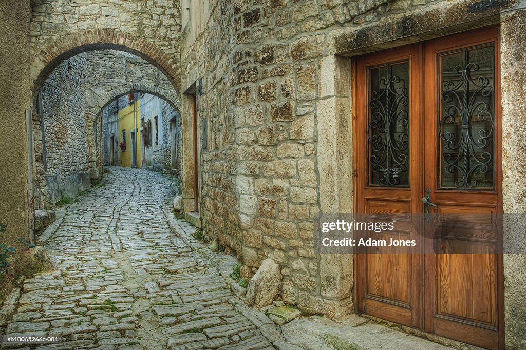 Arches over cobblestone street and wooden doorway