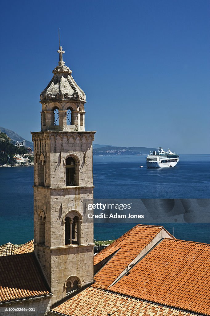 Church bell tower and cruise ship docked in Adriatic Sea