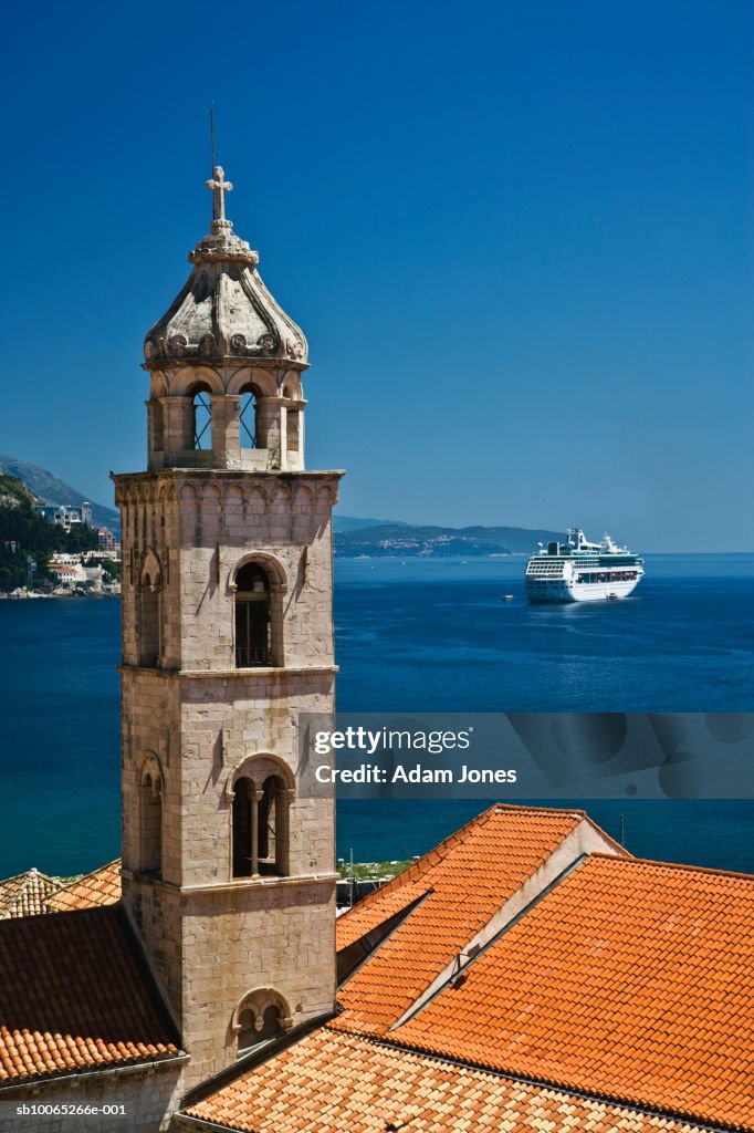 Church bell tower and cruise ship docked in Adriatic Sea