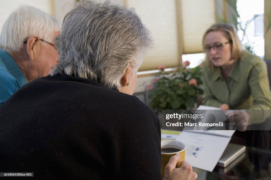 Three people talking around table