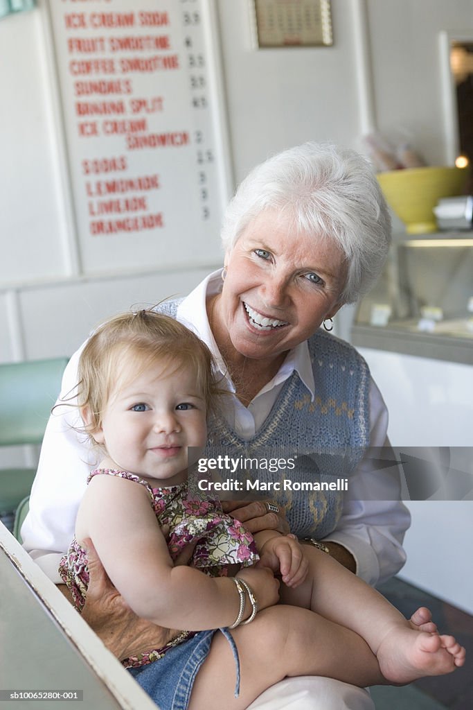 Senior woman and baby girl (9-12 months) inside cafe