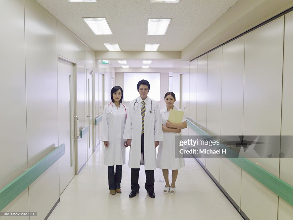 Doctor and two nurses in hospital corridor, portrait